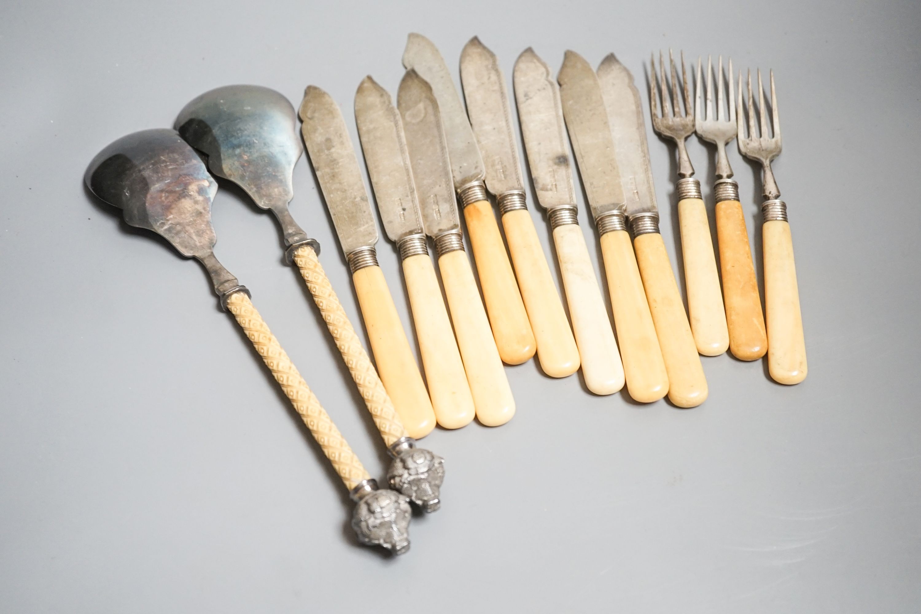 Eight ivory handled silver fish knives and three forks and a pair of plated servers.